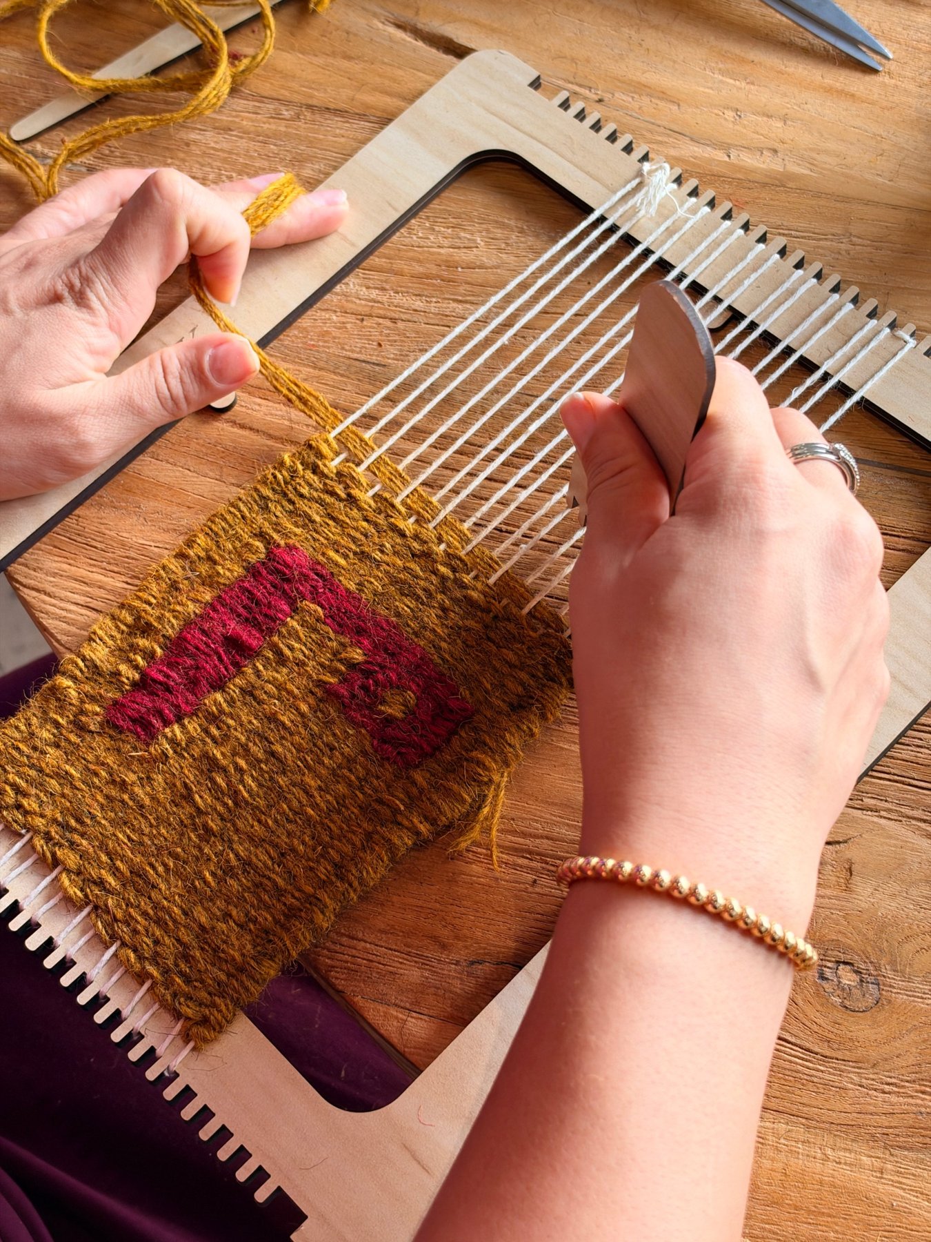 Weaving a pattern in mustard and red wool