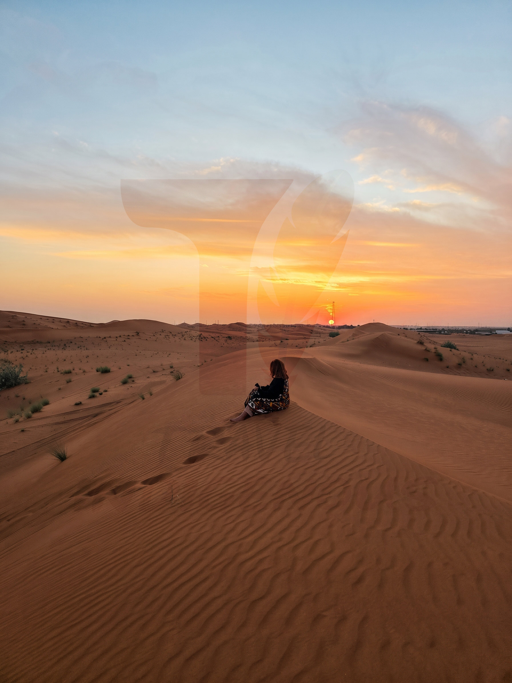 ضيفة تتأمل الغروب فوق الكثبان الرملية